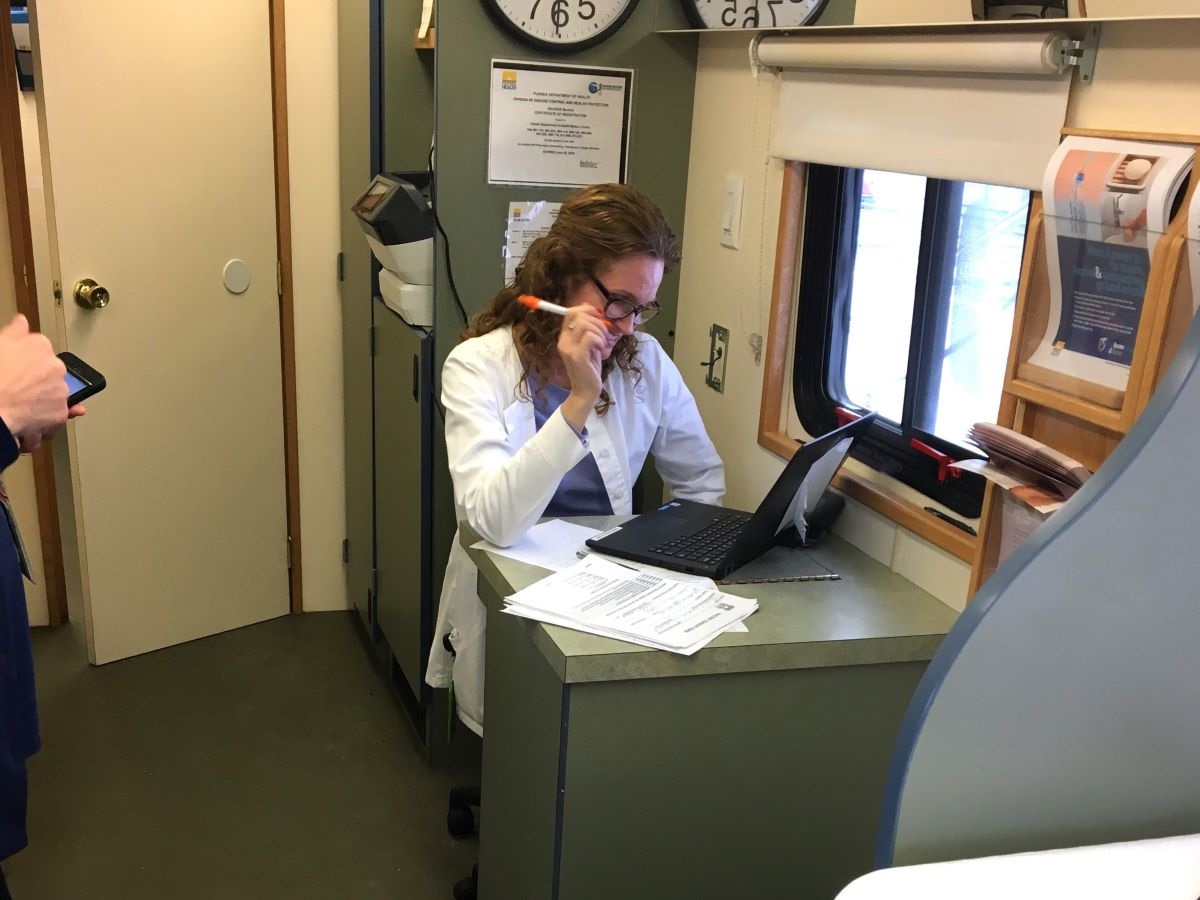 A Mobile Health Unit staff member reviews documents.
