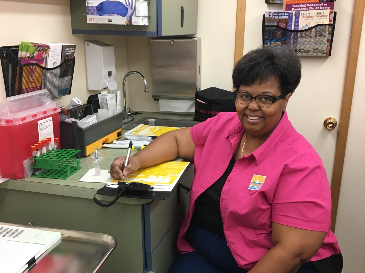 A Mobile Health Unit staff member fills out a form.